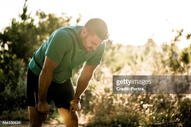 moe mannelijke atleet buigen in bos - buigen lichaamsbeweging stockfoto's en -beelden
