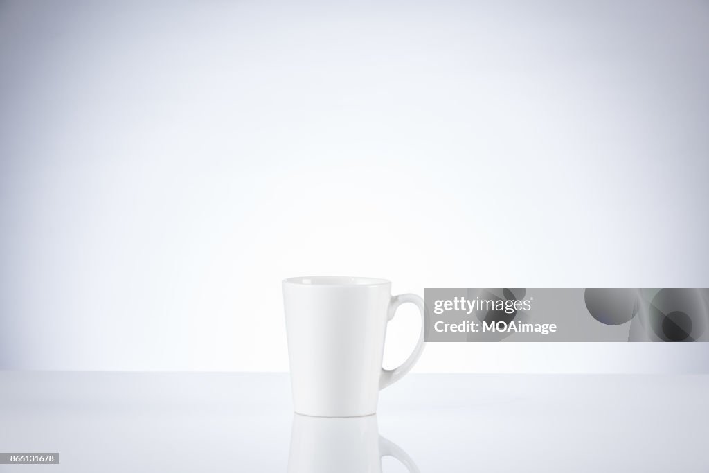 A white porcelain cup on a table indoors