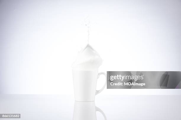 a piece of chocolate splashing in the cup of milk - chocolate milk splash stock pictures, royalty-free photos & images