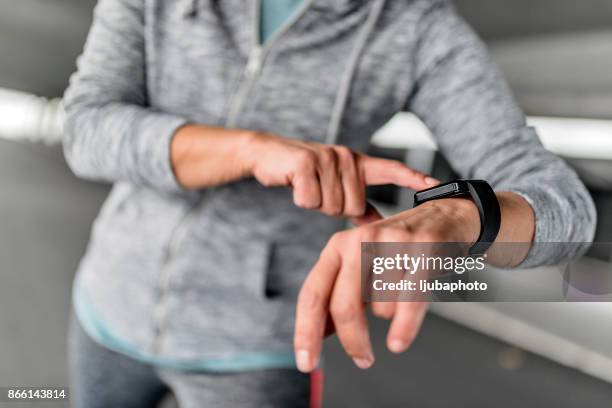 sportswoman checking time on smartwatch - competition time stock pictures, royalty-free photos & images