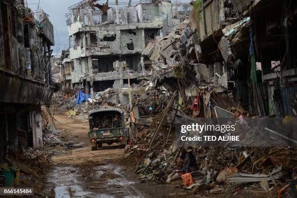 Bombed-out buildings are seen as government troops board trucks in what was the main battle area in Marawi on the southern island of Mindanao on...