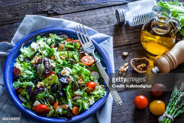 frisse salade plate op rustieke houten tafel - radicchio stockfoto's en -beelden