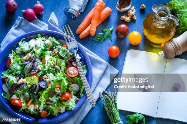 fresh salad plate with cookbook on bluish kitchen table - rocket book stock pictures, royalty-free photos & images