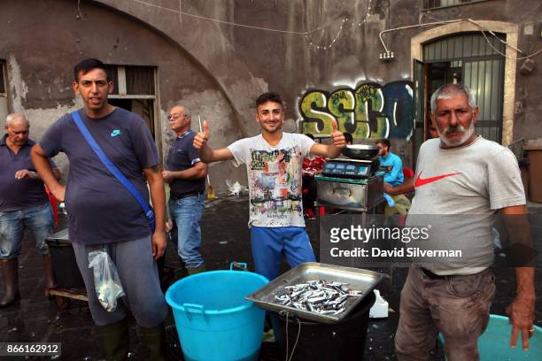 Traders and fishermen sell the day's catch of fresh fish and seafood at La Pescheria, the local fish market, on September 26, 2017 in Catania on the...