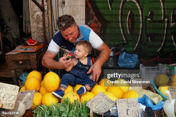 Young Italian boy eats watermelon at a produce stall at La Pescheria, the local fish market, on September 26, 2017 in Catania on the Italian island...