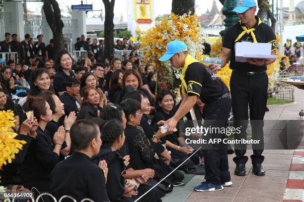 This picture by Thailand's Dailynews shows Prince Dipangkorn Rasmijoti handing out food and water to well-wishers in Bangkok on October 25 near the...