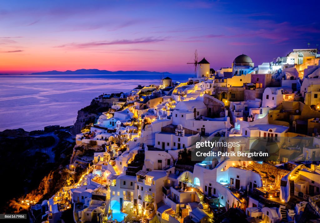 Colorful landscape photo of the traditional village of Oia during dusk