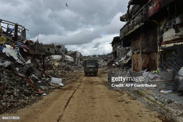 Military vehicle drives past bombed-out buildings in what was the main battle area in Marawi on the southern island of Mindanao on October 25 days...