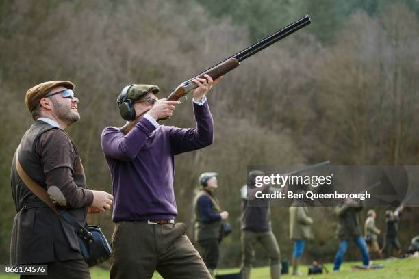 a man aiming a shot gun at clay pigeons - skeet shooting stock pictures, royalty-free photos & images