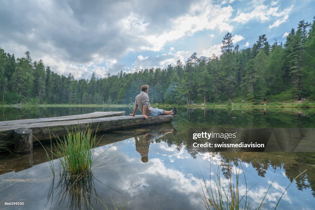 Young man contemplating nature by the lake, Switzerland