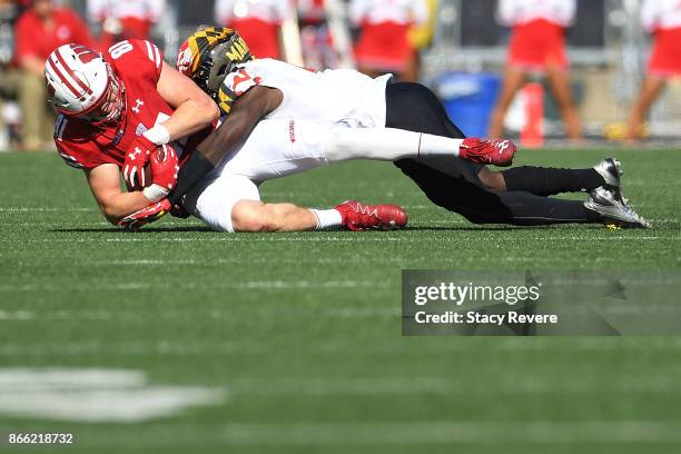 Troy Fumagalli of the Wisconsin Badgers is brought down by Darnell Savage Jr. #4 of the Maryland Terrapins during a game at Camp Randall Stadium on...