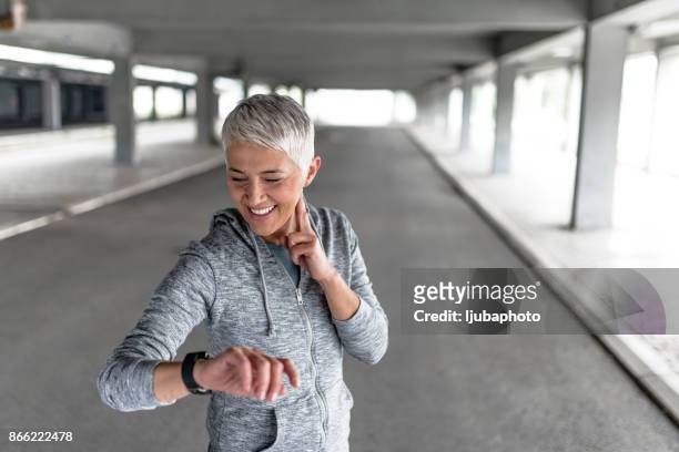 watching her heart rate - checking sports stock pictures, royalty-free photos & images