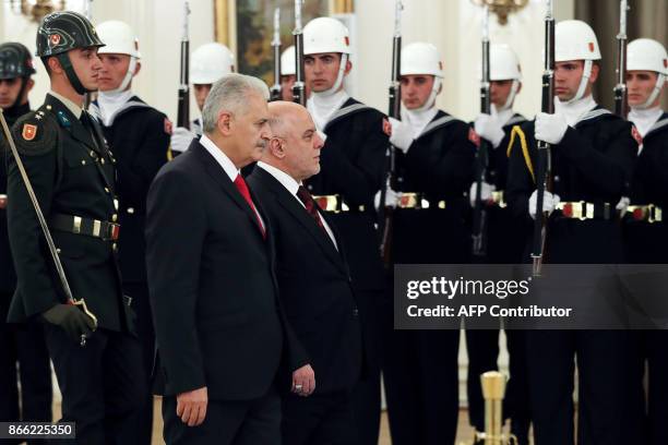 Iraqi Prime Minister Haider Al-Abadi walks with Turkish Prime Minister Binali Yildirim during an official welcoming ceremony at the Cankaya Palace in...