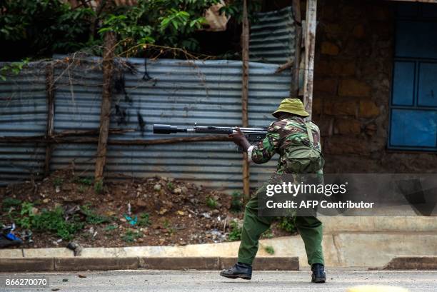 An anti-riot policeman holds a weapon during a protest on October 25, 2017 in the Kondele district of Kisumu, an opposition stronghold in western...