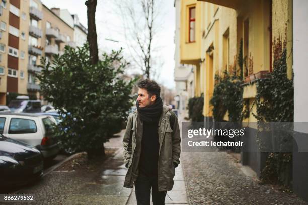 young man walking in berlin - parka stock pictures, royalty-free photos & images