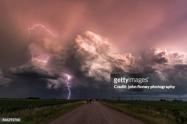 electric storm at sunset watched by a group of storm chasers. usa - storm cloud stockfoto's en -beelden