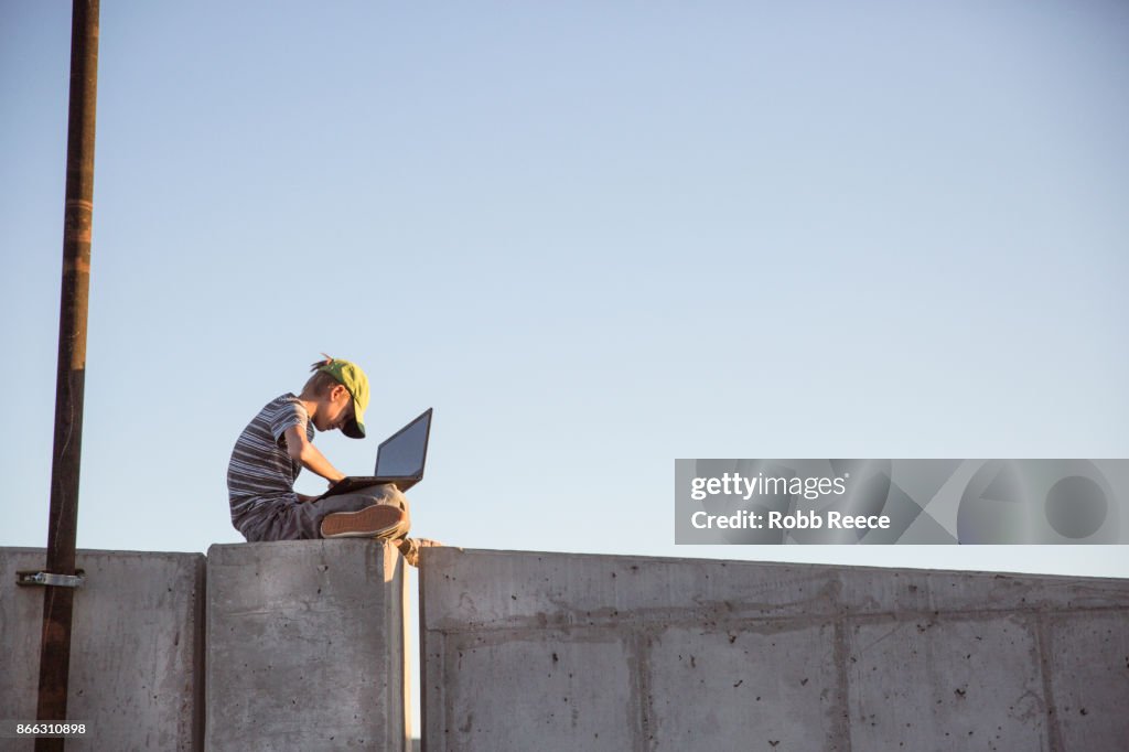 A teenage boy hacking with a laptop computer to commit cyber crime