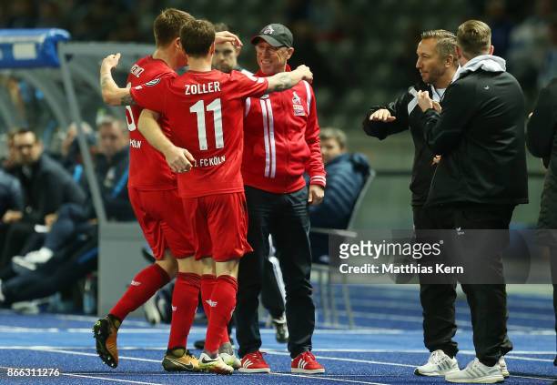 Simon Zoller of Koeln jubilates with team mates and head coach Peter Stoeger after scoring the first goal during the DFB Cup match between Hertha BSC...