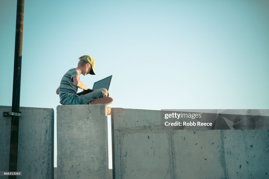 A teenage boy hacking with a laptop computer to commit cyber crime