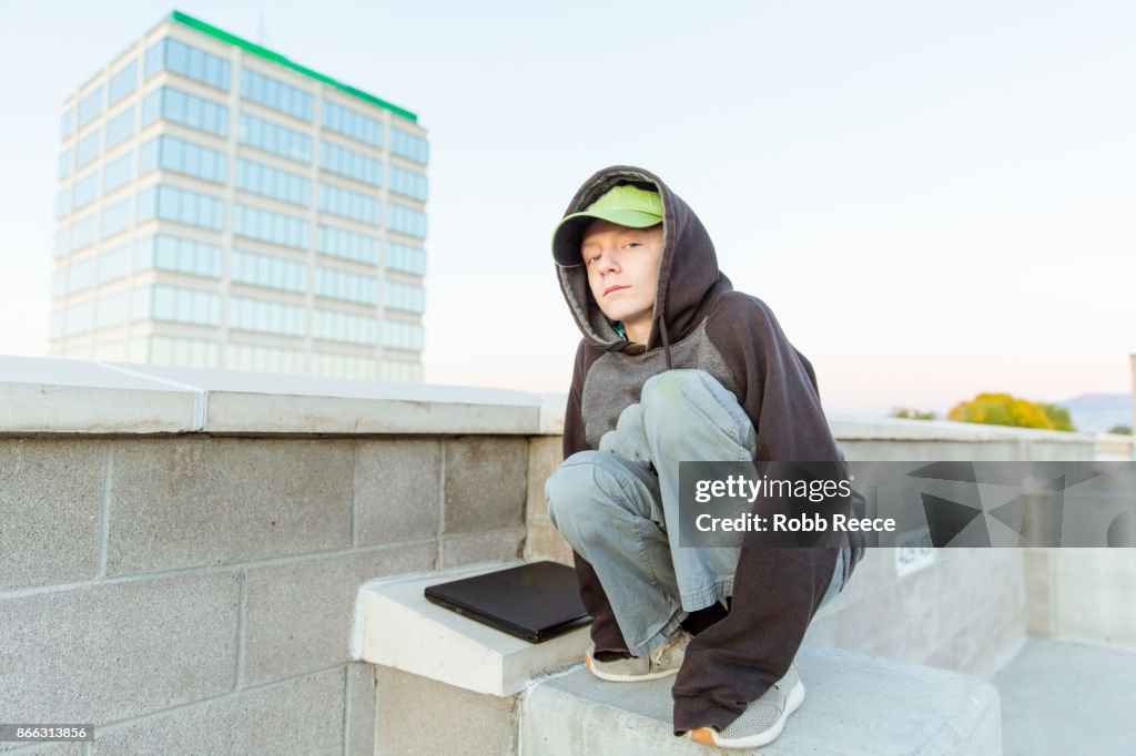 A teenage boy hacking with a laptop computer to commit cyber crime