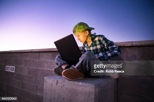 a teenage boy hacking with a laptop computer to commit cyber crime - robb reece stock pictures, royalty-free photos & images