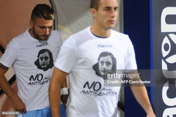 Lazio's midfielder Ciro Immobile and teammates wear t-shirts against antisemitism showing an image of holocaust victim Anne Frank, during the warm up...