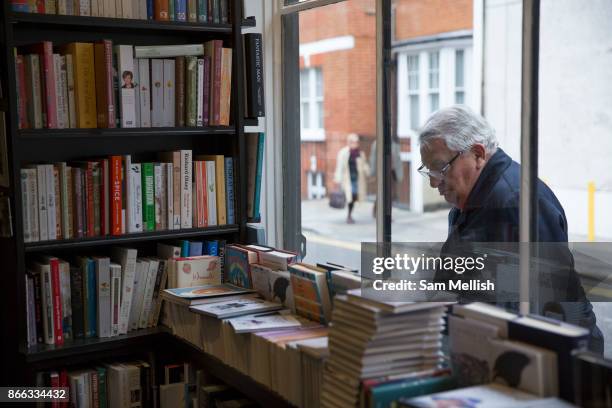 Man looks through the window of John Sandoe bookshop on 19th October 2015 in London, United Kingdom. Independent bookshop since 1957, crammed with...