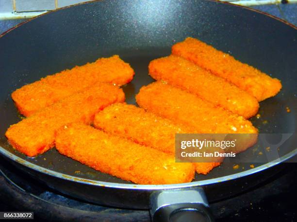 fish fingers frying in pan - fish stick stock pictures, royalty-free photos & images