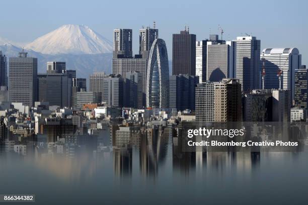 mount fuji and buildings in the shinjuku district are reflected - fiscal policy stockfoto's en -beelden