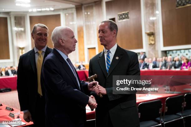 Sen. John McCain hands over the gavel to Rep. Mac Thornberry at the start of an Armed Services conference committee meeting on the National Defense...