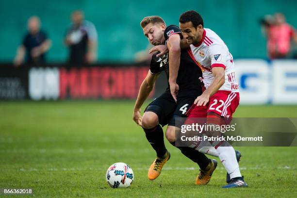 Dilly Duka of the New York Red Bulls and Russell Canouse of DC United battle for the ball in the first half at RFK Stadium on October 22, 2017 in...