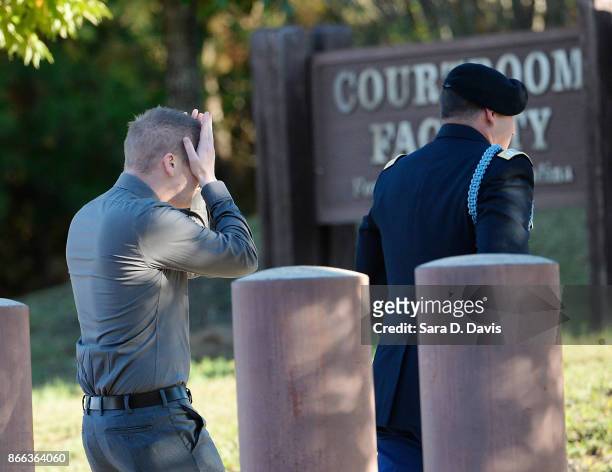 Former U.S. Army Sgt. Evan Buetow, wipes his face as he arrives at the Ft. Bragg military courthouse with U.S. Army Col. John Billings on October 25,...