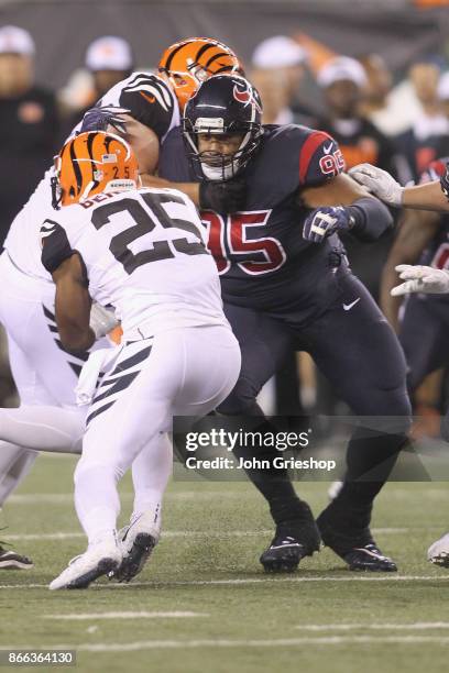 Giovani Bernard of the Cincinnati Bengals runs the football upfield against Christian Covington of the Houston Texans during their game at Paul Brown...