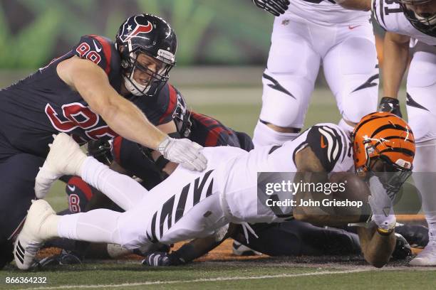 Jeremy Hill of the Cincinnati Bengals runs the football upfield against J.J. Watt of the Houston Texans during their game at Paul Brown Stadium on...