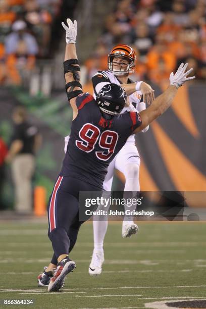 Andy Dalton of the Cincinnati Bengals throws the football away against the rush of J.J. Watt of the Houston Texans during their game at Paul Brown...