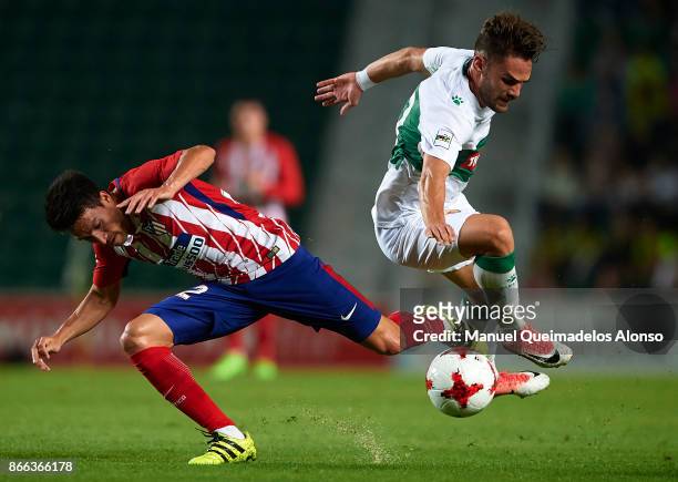 Lolo of Elche competes for the ball with Nico Gaitan of Atletico de Madrid during the Copa del Rey first leg match between Elche CF and Atletico de...