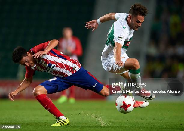 Lolo of Elche competes for the ball with Nico Gaitan of Atletico de Madrid during the Copa del Rey first leg match between Elche CF and Atletico de...