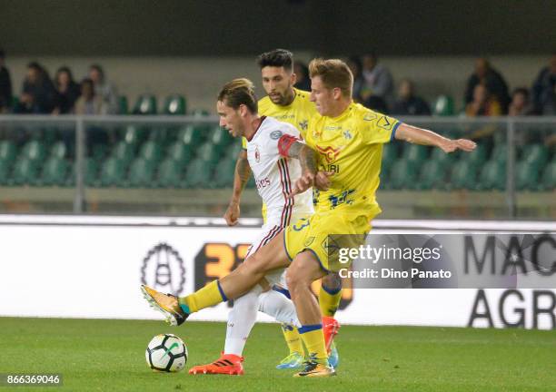 Valter Birsa of AC Chievo Verona competes with Lucas Biglia of AC Milan during the Serie A match between AC Chievo Verona and AC Milan at Stadio...