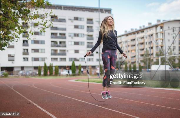 woman exercising with a jump rope - skipping rope stock pictures, royalty-free photos & images