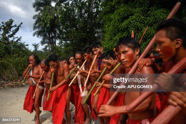 Waiapi men dance and play flute during the Anaconda's party -during which they make flutes to play and dance, and at the end leave all flutes on the...