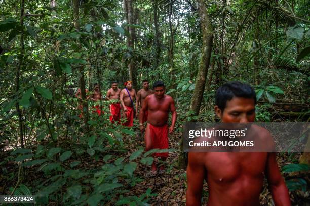 Waiapi men walk into the jungle at the Waiapi indigenous reserve in Amapa state in Brazil on October 14, 2017. When Waiapis walks into the Amazon...