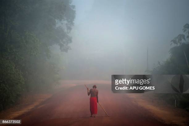 Tribal chieftain Tzako Waiapi walks in the fog at the Manilha village in Waiapi indigenous reserve in Amapa state in Brazil on October 13, 2017....