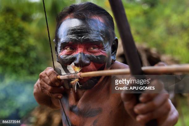 Waiapi man aims bow and arrow at the Waiapi indigenous reserve in the Manilha village, in Amapa state, Brazil, on October 13, 2017. The Waiapi are...