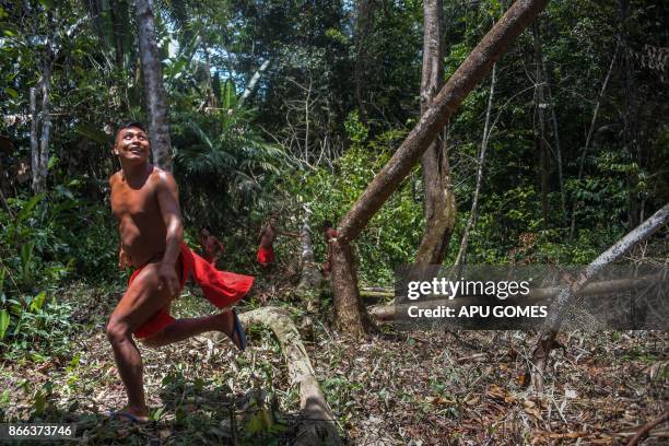 Waiapi man runs after cutting down a tree to make a manioc field, at the Waiapi indigenous reserve in Amapa state in Brazil on October 14, 2017. When...