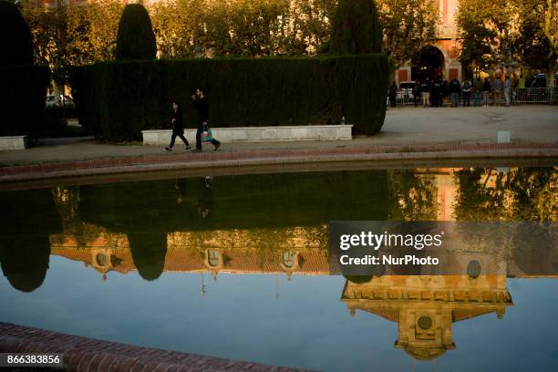 People passes by as Catalonian Parliament building is seen reflected on the water in Barcelona, Spain, on 25 October, 2017. Spanish government aims...