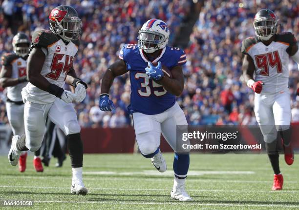 Mike Tolbert of the Buffalo Bills carries the ball for a big gain during NFL game action as Lavonte David of the Tampa Bay Buccaneers chases him down...