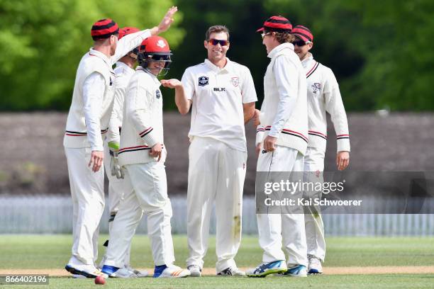 Tim Johnston of Canterbury is congratulated by team mates after dismissing Neil Broom of Otago for 48 runs during the Plunket Shield match between...