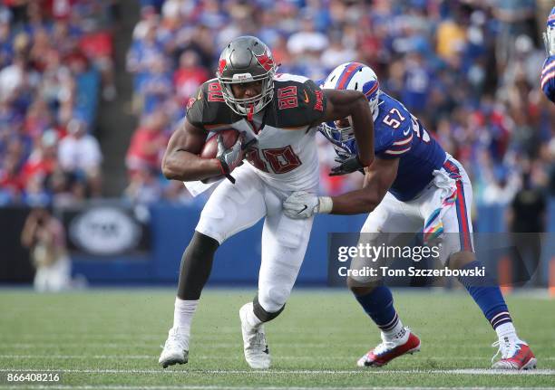 Howard of the Tampa Bay Buccaneers runs after making a catch as he tries to break a tackle during NFL game action as Lorenzo Alexander of the Buffalo...