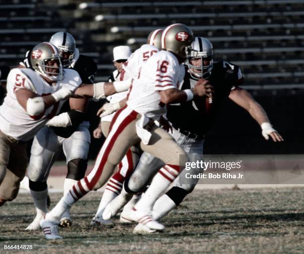 San Francisco quarterback Joe Montana scrambles to avoid LA Raider's Howie Long during San Francisco 49'ers game against Los Angeles Raiders, August...