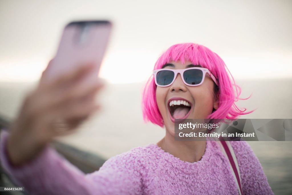 Young woman with pink hair taking a selfie